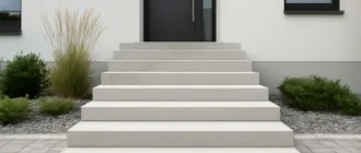 Außentreppe aus Betonwerkstein mit heller, feingeschliffener Oberfläche vor einem Hauseingang
