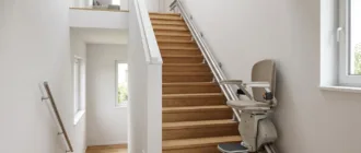 Gerader Sitzlift an einer hellen Innentreppe