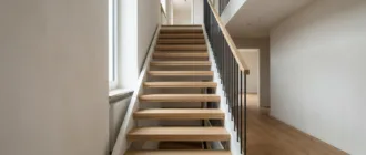 Gerade Treppe mit Holzstufen und offenem Setzstufenbereich in einem modernen Wohnhaus