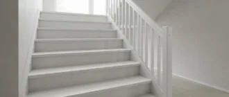 Frisch gestrichene weiße Holztreppe in einem hellen Treppenhaus