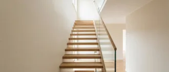 Kleine Treppe mit heller Wandfarbe und transparentem Glasgeländer wirkt optisch größer