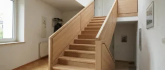Treppengeländer mit heller Holzverkleidung an einer Innentreppe